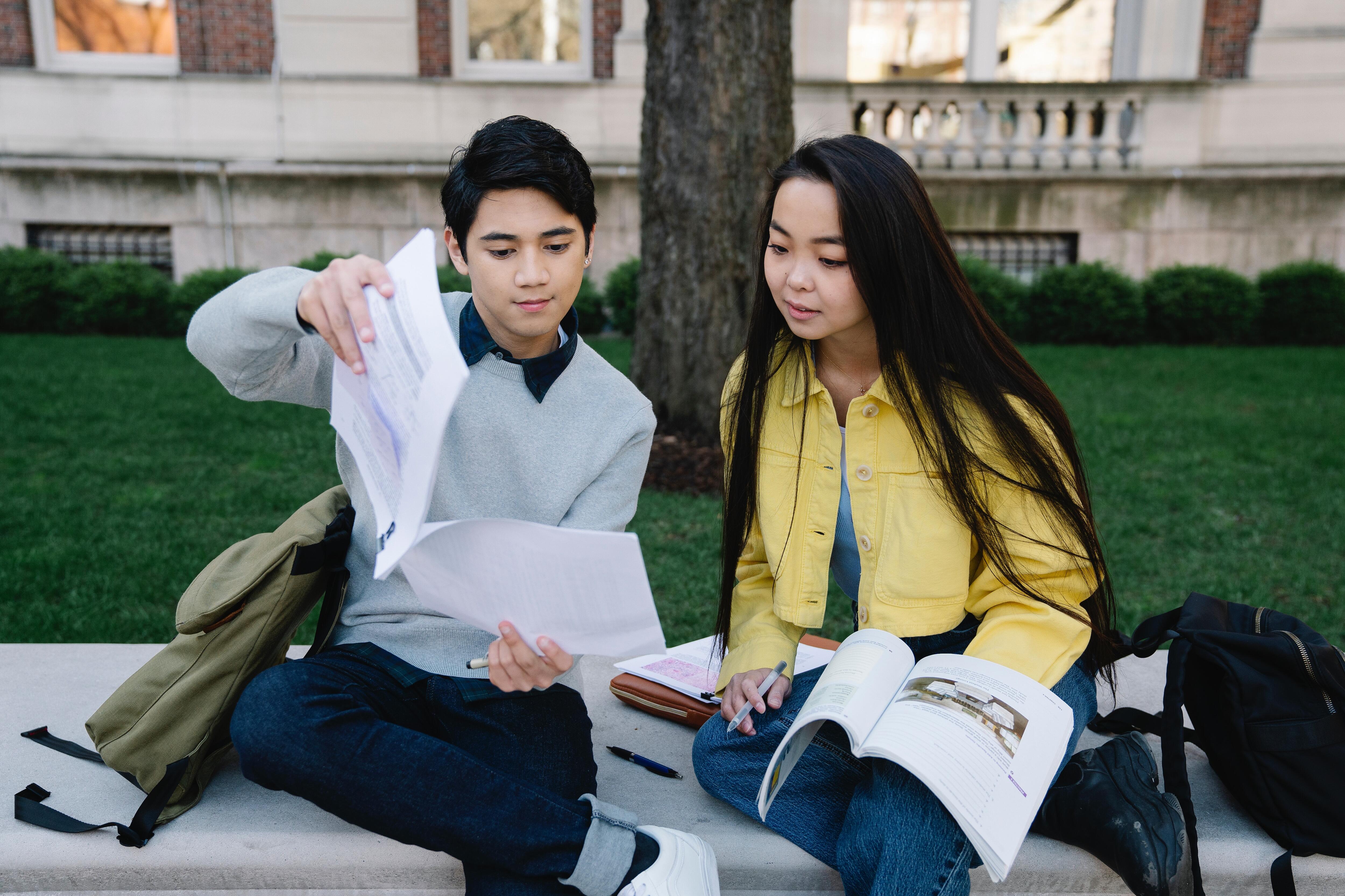two students studying outdoors
